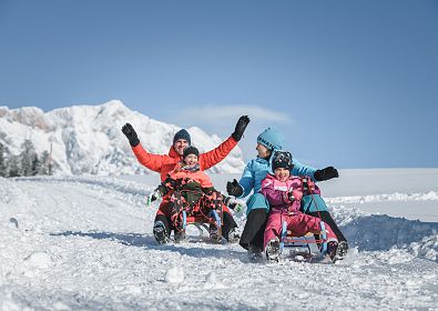 Familie beim Rodeln in der Region Hochkönig